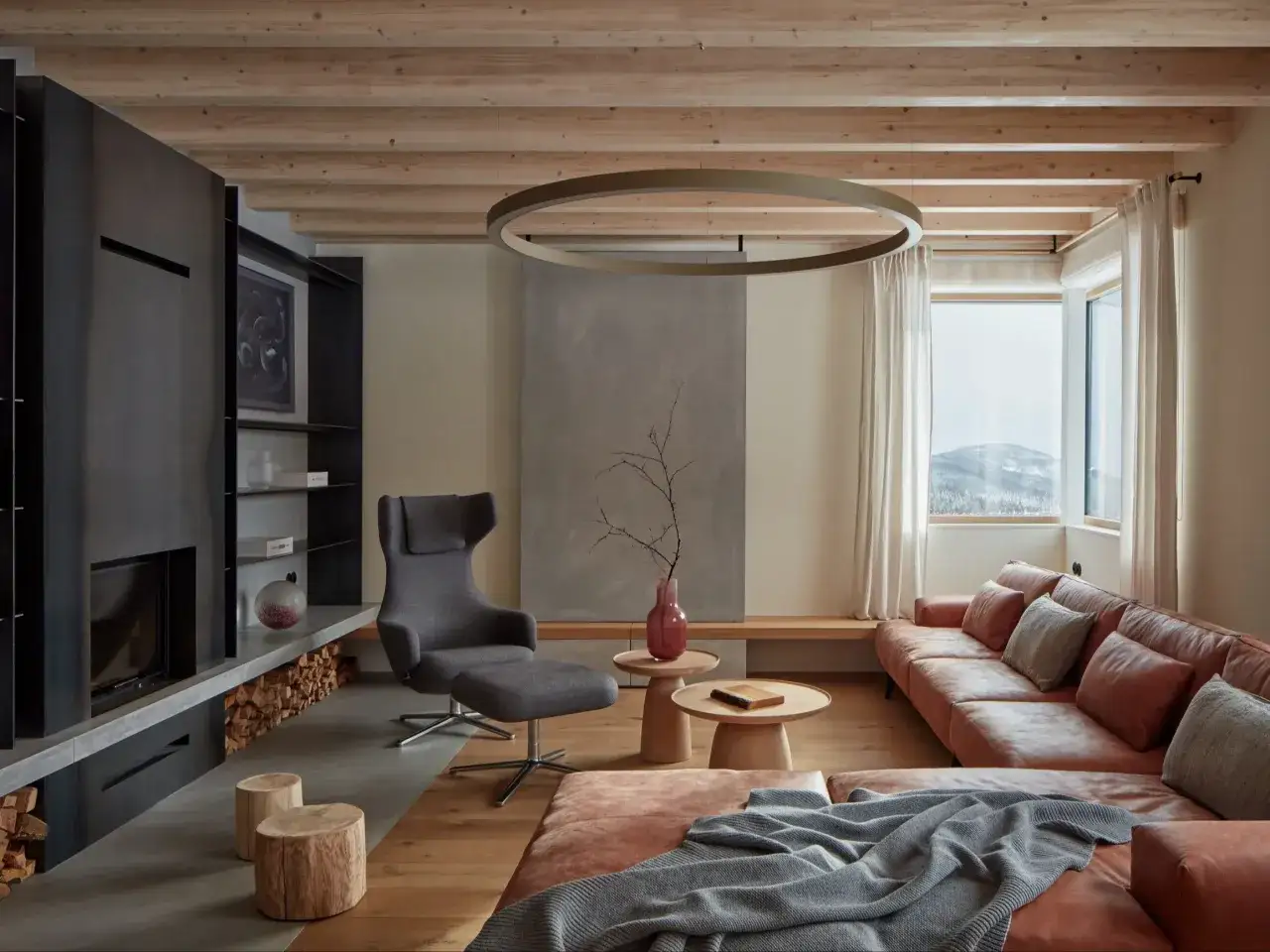 Nowoczesny salon w stylu modern farmhouse z kominkiem, sk&oacute;rzaną kanapą i drewnianymi belkami na suficie.