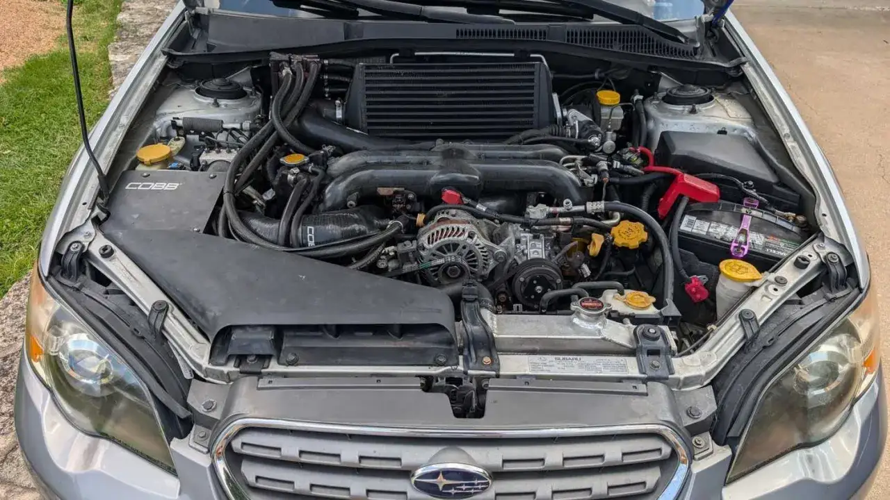 Motorutrymmet p&aring; en silverf&auml;rgad Subaru Outback. En COBB-platta syns. Kanske ett Subaru Outback problem som beh&ouml;ver &aring;tg&auml;rdas.