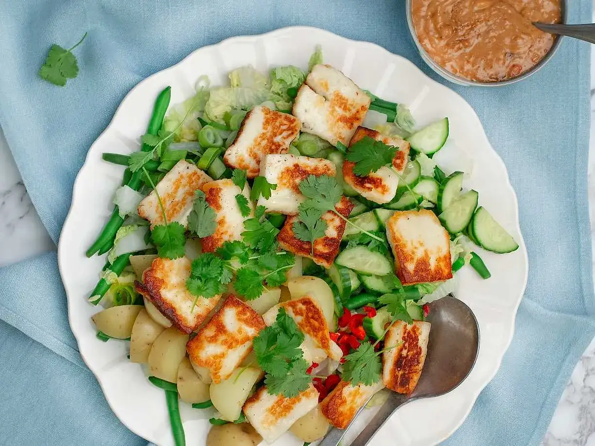 En fr&auml;sch sallad med stekt halloumi, potatis, gr&ouml;na b&ouml;nor, gurka och koriander, serverad med en jordn&ouml;tsdressing. En h&auml;rlig gado gado-inspirerad r&auml;tt.
