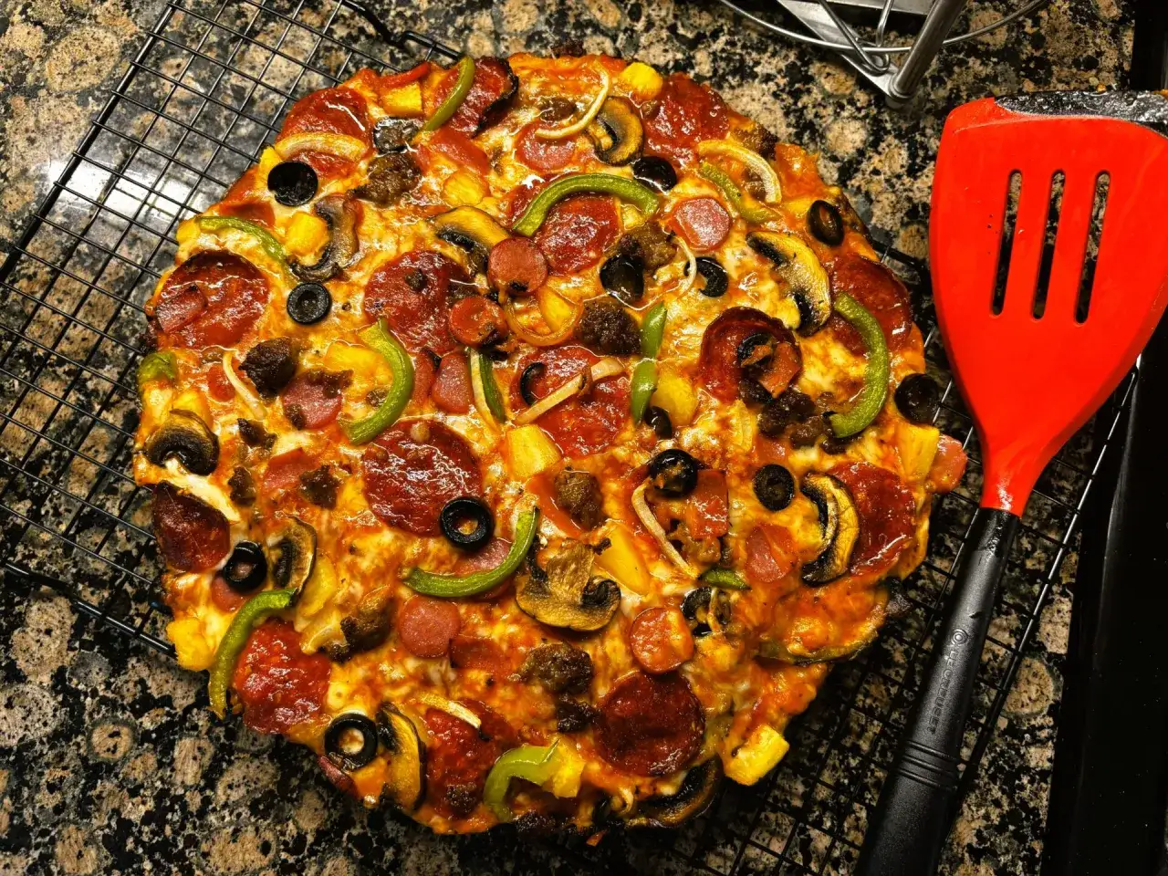 Pyszna pizza supreme z Pizza Hut, pełna pieczarek, papryki, oliwek i pepperoni, czeka na talerzu.