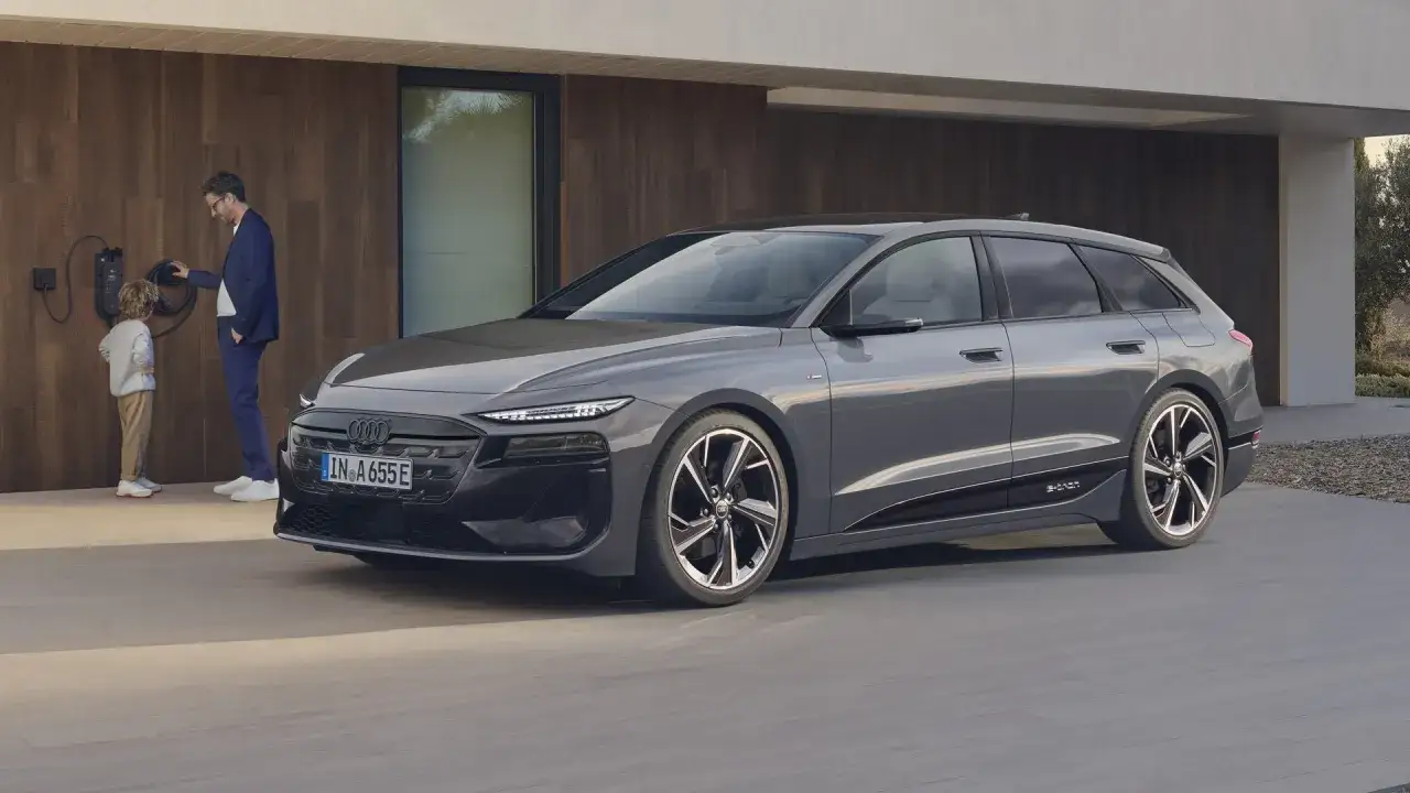 Ojciec i syn ładują Audi A6 e-tron przy domu.