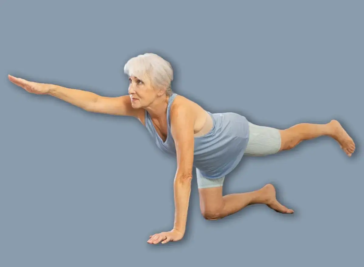 Donna anziana in posizione yoga, braccio e gamba tesi, per raddrizzare la schiena a 50 anni e oltre.