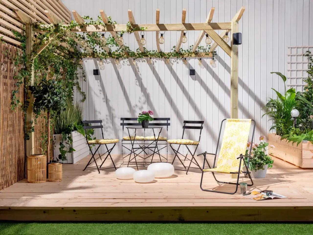 En mysig uteplats med pergola, m&ouml;bler och v&auml;xter. Perfekt f&ouml;r att bygga insynsskydd och njuta av sommaren.