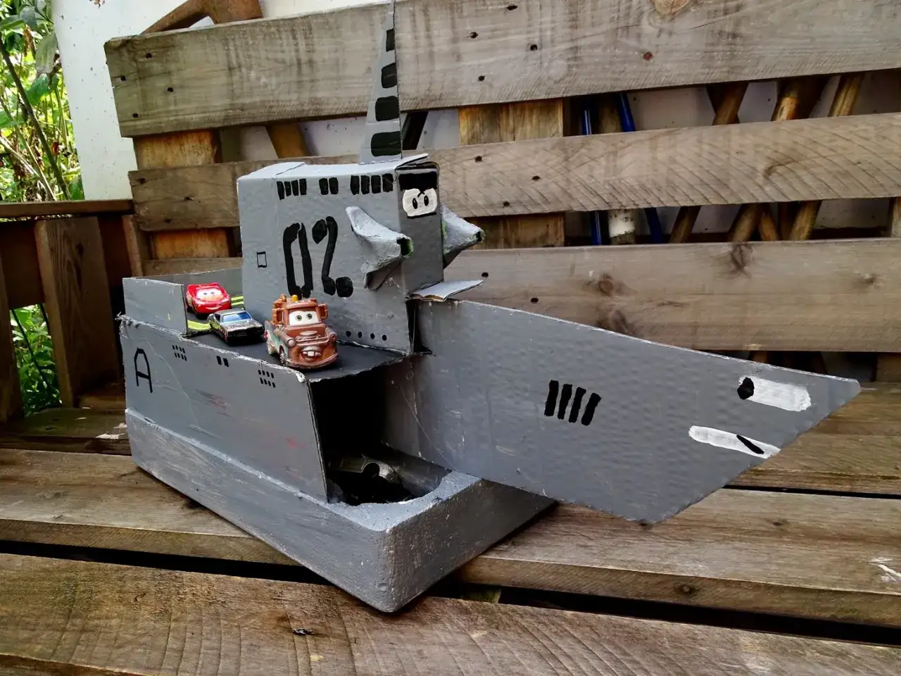 Kreative **Upcycling Ideen**: Ein U-Boot aus Pappe mit Spielzeugautos, das zum Spielen einl&auml;dt.