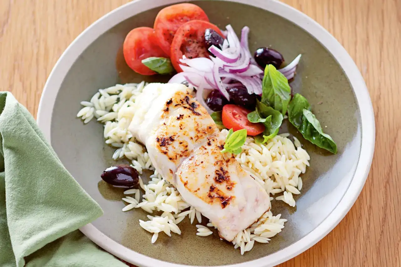 Poisson grill&eacute; sur lit d'orzo, garni de tomates, olives, oignons rouges et basilic, le tout napp&eacute; d'une sauce vierge fra&icirc;che.