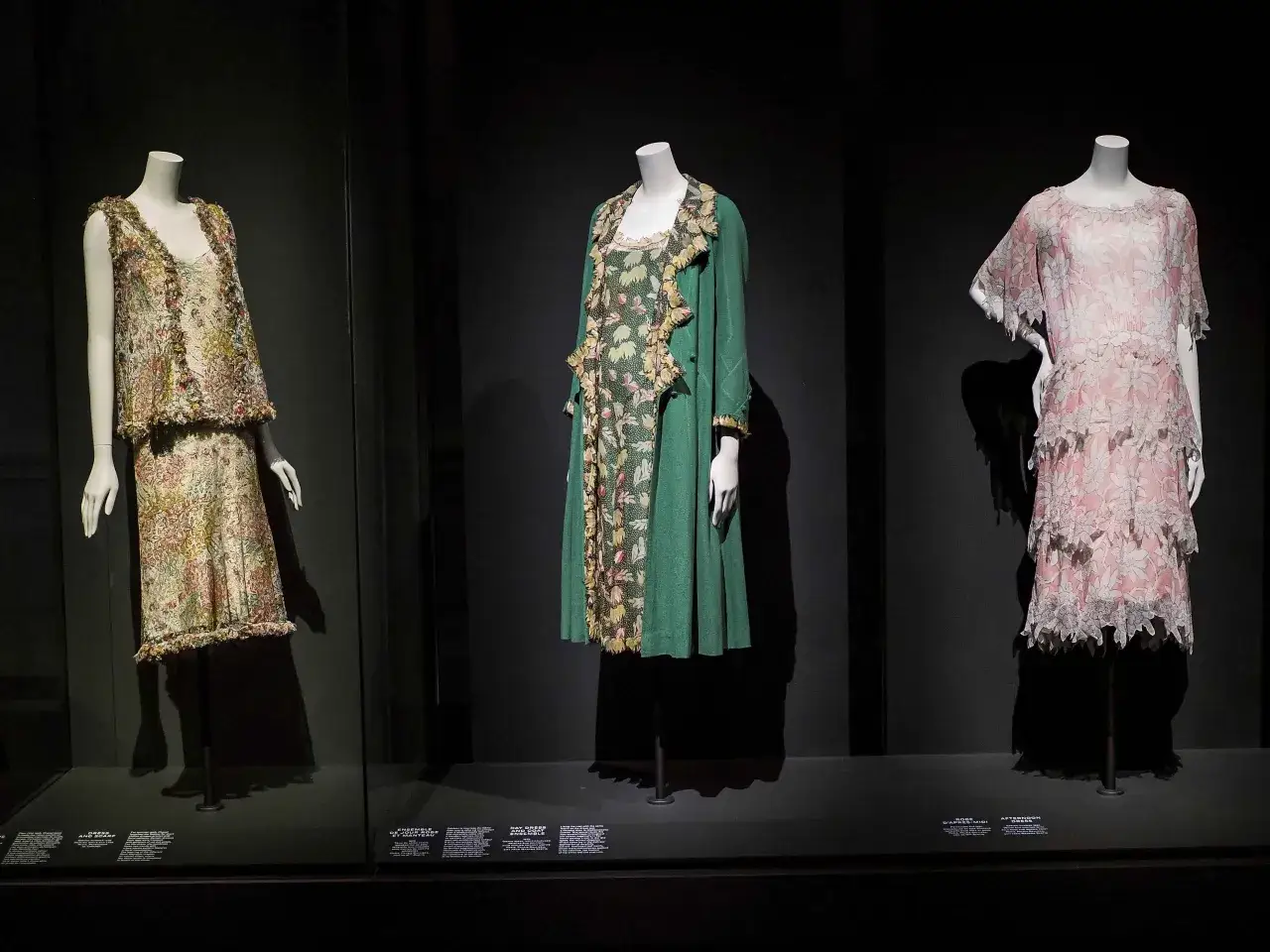 Abiti d'epoca in mostra, un tuffo nella storia Chanel con abiti floreali e un tailleur verde.
