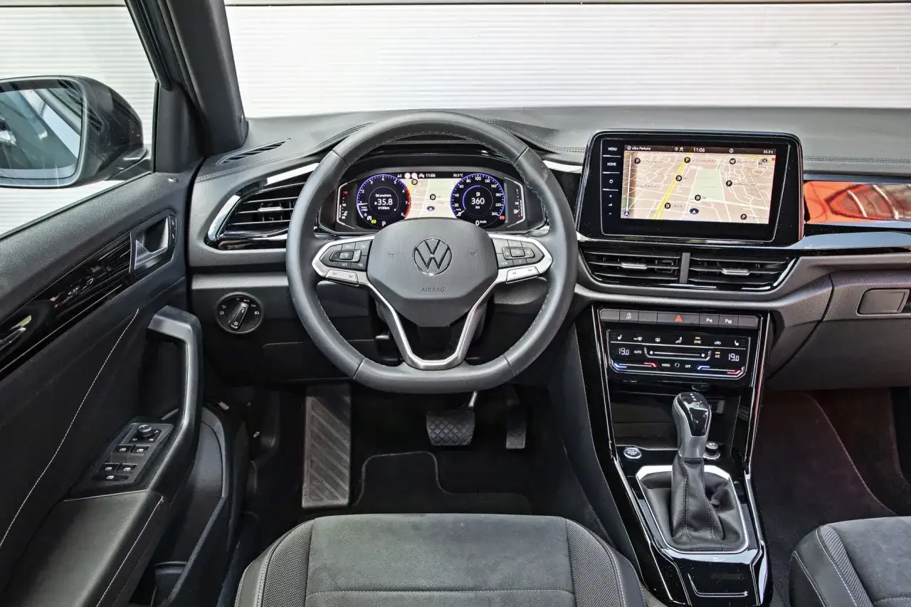 Wnętrze Volkswagena T-Roc z ekranem nawigacji i cyfrowymi zegarami. Sprawdź aktualną volkswagen t-roc cena i wyposażenie.