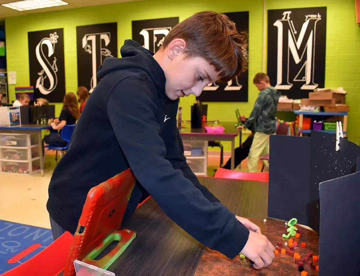 Junge gestaltet eine Szene für Stop-Motion-Animation in der Grundschule.