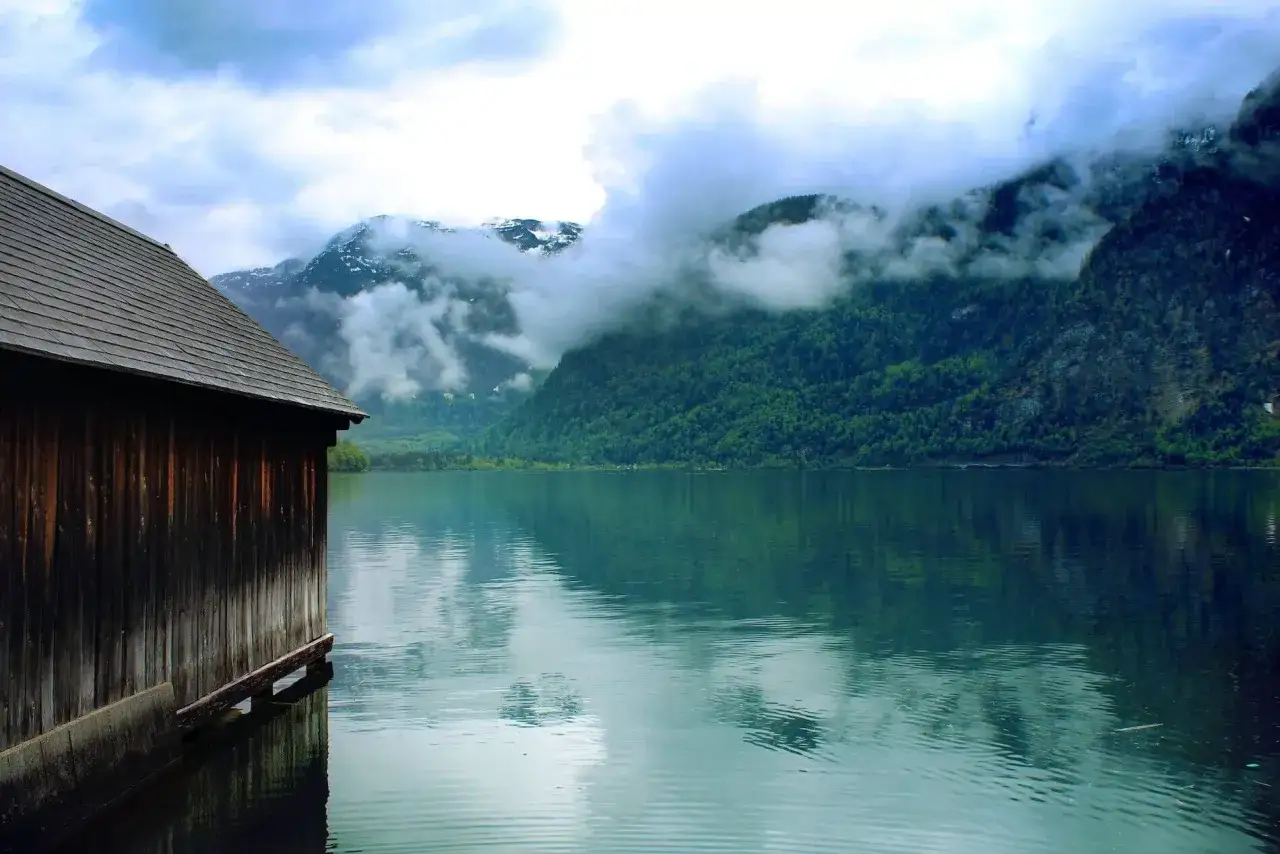 Holzh&uuml;tte am See mit Bergen im Hintergrund. Ein idyllischer Ort f&uuml;r einen Campingplatz Deutschland.
