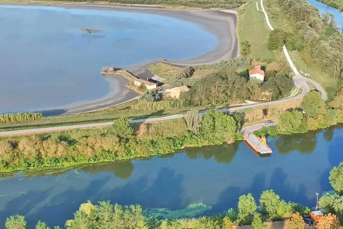 Nuova ciclabile Valli di Comacchio: mappa aerea con traghetto sul fiume, case rurali e specchi d'acqua.