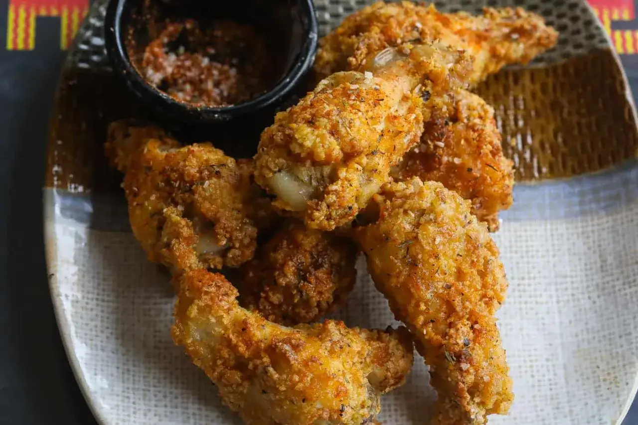 Chrupiące skrzydełka z airfryer, idealne na przekąskę, podane z pikantną przyprawą.