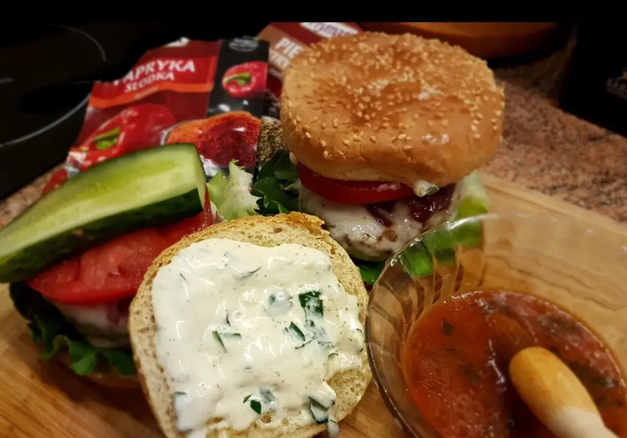 Pyszne burgery z grilla, z chrupiącą bułką, soczystym mięsem, warzywami i kremowym sosem. Idealne na letnie popołudnie.