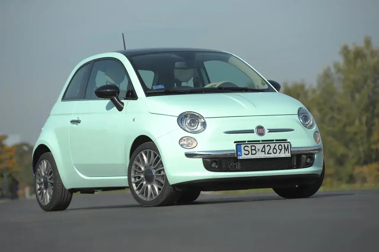 Miętowy Fiat 500 z czarnym dachem, idealny do miasta. Sprawdź jego kompaktowe fiat 500 wymiary.