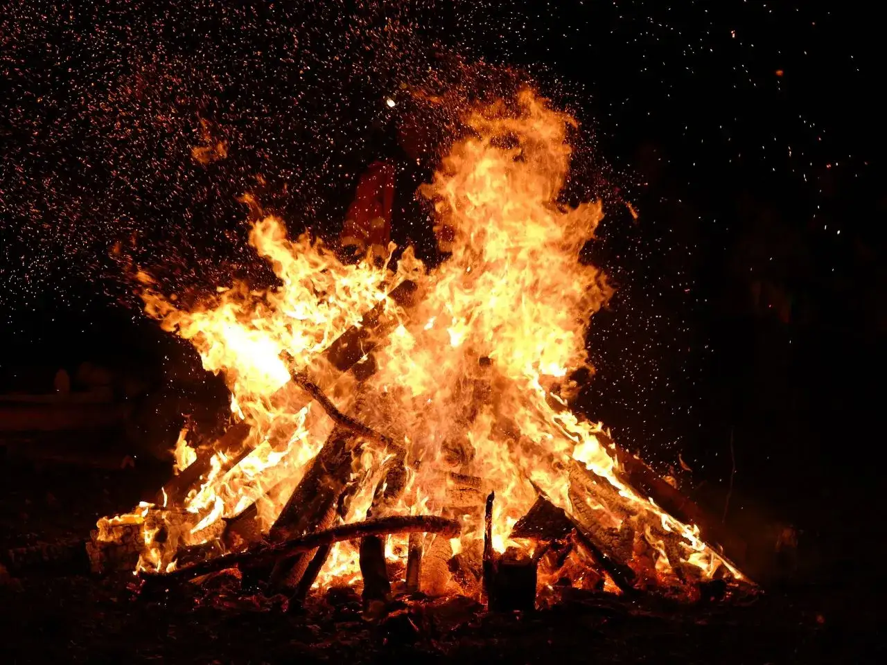 Un grande fal&ograve; illumina la notte, con scintille che danzano nell'aria. Un'atmosfera magica, perfetta per quando si festeggia la Madonna di Loreto.