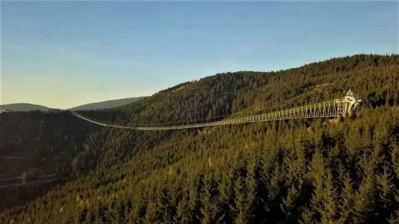Najdłuższy most w Czechach, wiszący nad gęstym lasem, łączy dwa zbocza g&oacute;rskie.