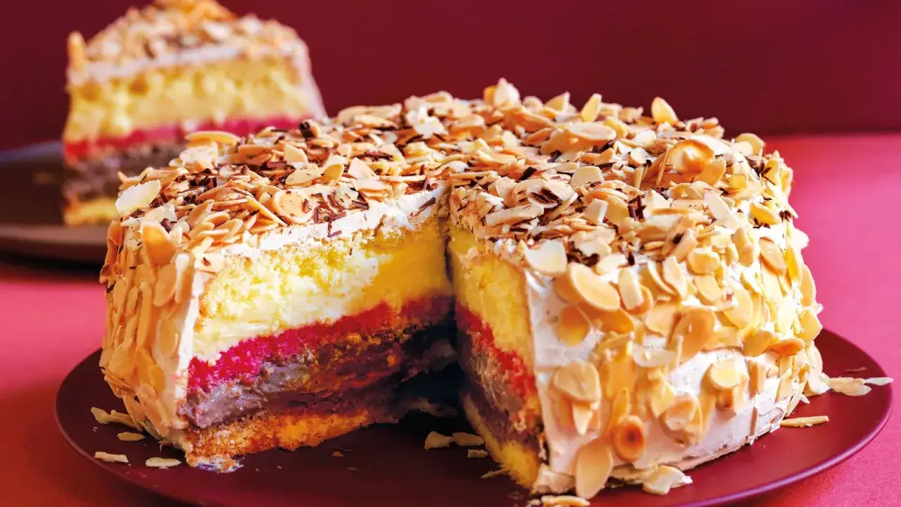Fetta di pizza dolce abruzzese con strati di crema, marmellata e cioccolato, ricoperta di mandorle a lamelle.