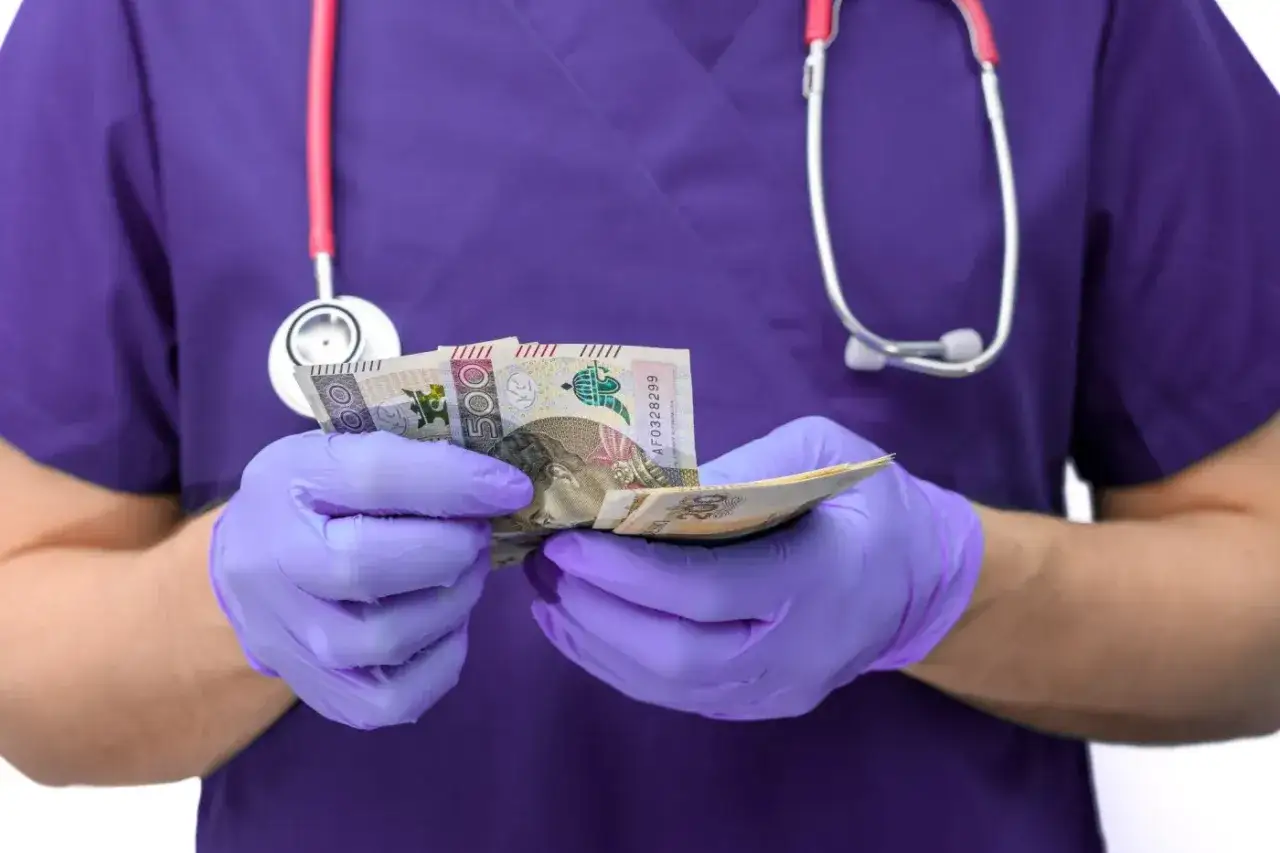 Medyk w fioletowym uniformie i rękawiczkach liczy pieniądze. Czy to cena za leczenie, czy może pytanie: oxycodone co to?