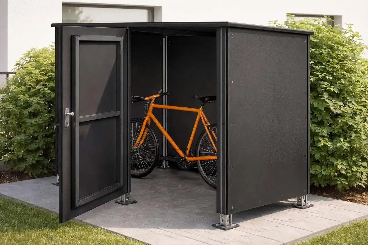Ein orangefarbenes Fahrrad steht in einem modernen, schwarzen Fahrradunterstand. Perfekt, wenn Sie einen Fahrradunterstand selber bauen möchten.