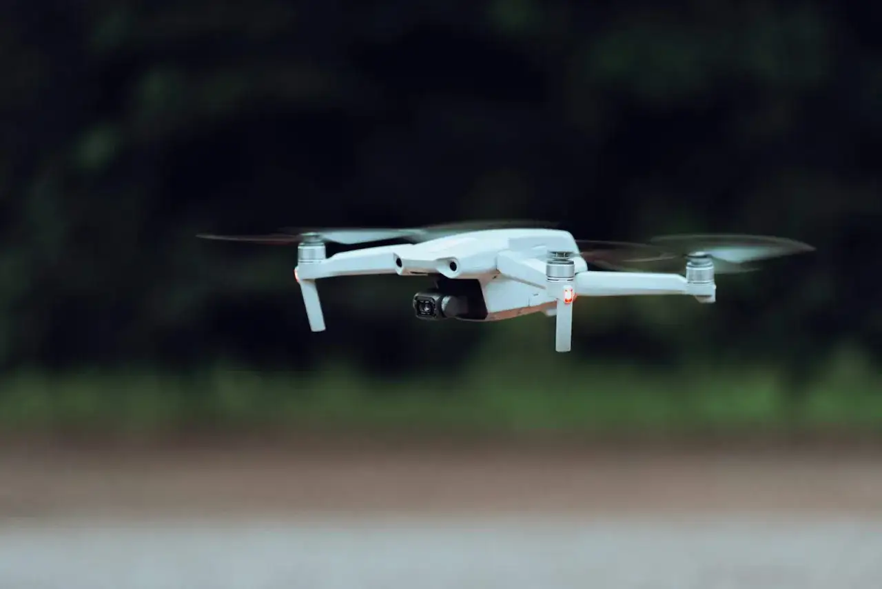 Biały dron z kamerą w locie, idealny do rankingu najlepsze drony dla początkujących ranking z uwzględnieniem przepisów.