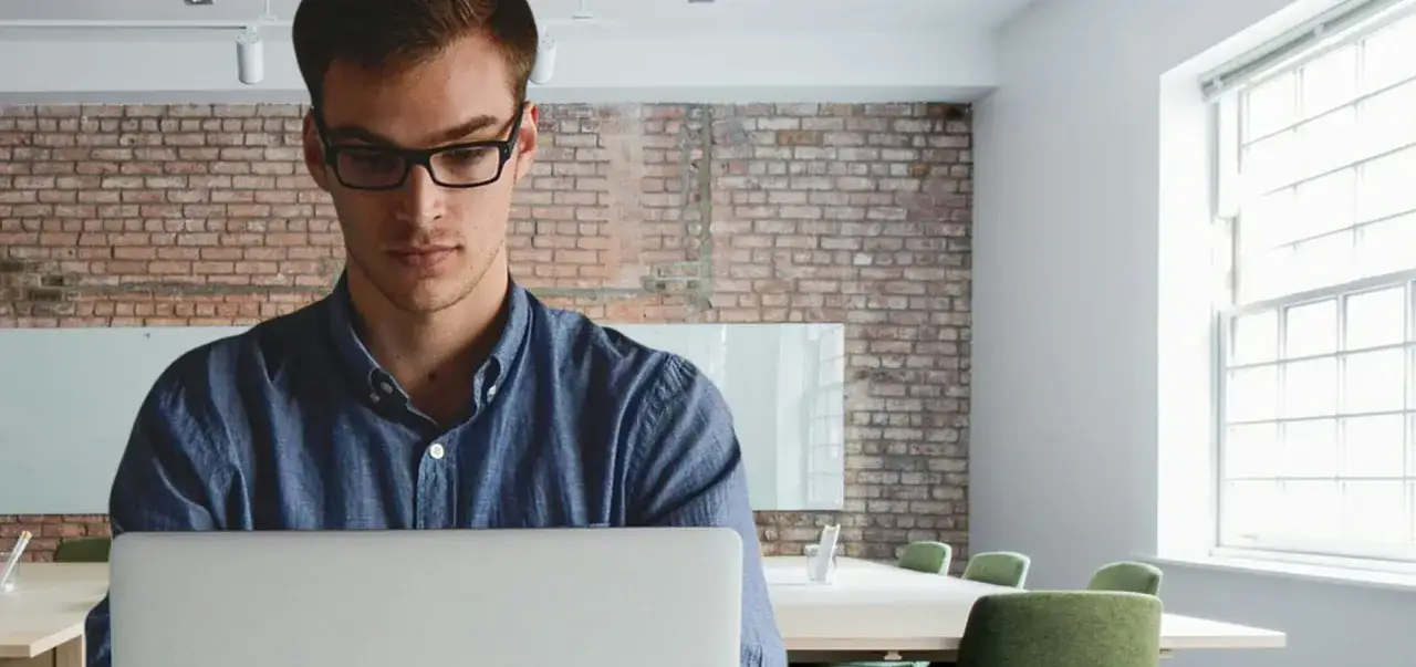 Man in glasses studies on laptop, perhaps researching the best online master's in organizational leadership for career growth.