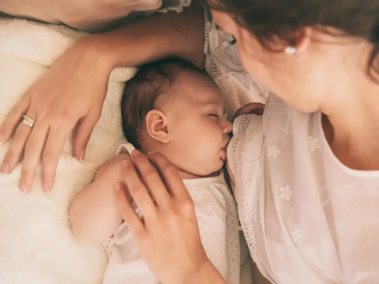 Mama karmi piersią dziecko. Czas karmienia jest indywidualny, ale nawał pokarmowy może być wyzwaniem.