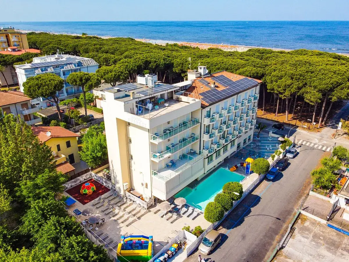 Vista aerea del **hotel Primula Azzurra** con piscina, area giochi e vista sul mare.