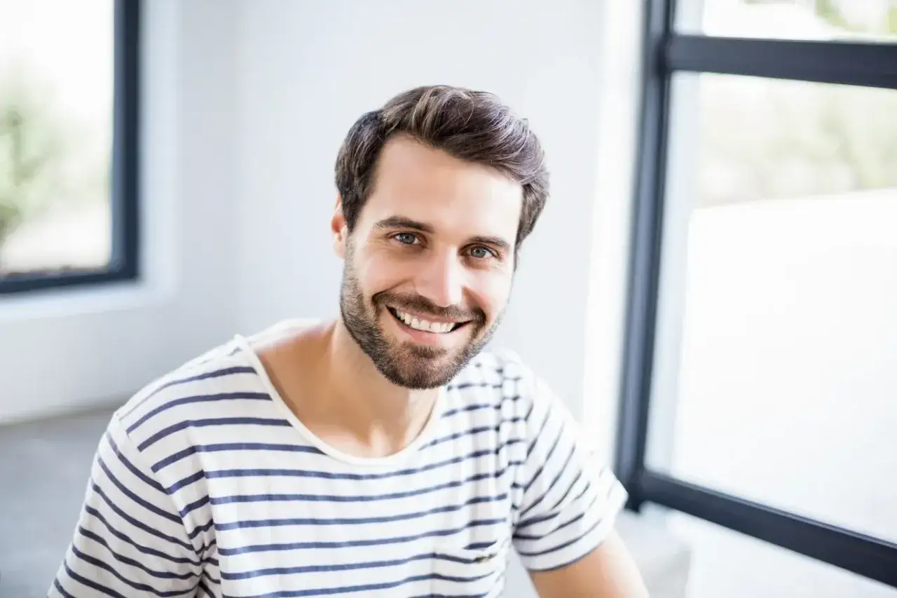Uśmiechnięty mężczyzna o imieniu Marcin, z brodą i w pasiastym t-shircie. Jego imię, Marcin, ma znaczenie