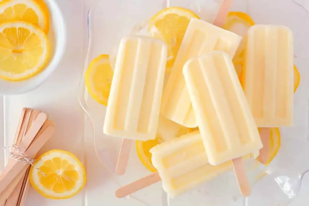 Erfrischendes Zitronen Wassereis selber machen: Cremige Eis am Stiel mit frischen Zitronenscheiben und Holzstäbchen.