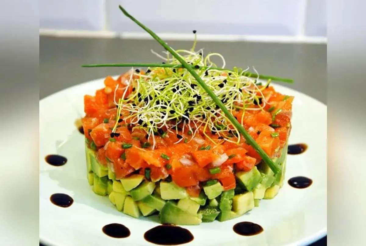 Un délicieux tartare de saumon avocat, garni de pousses fraîches et de quelques touches de sauce soja.