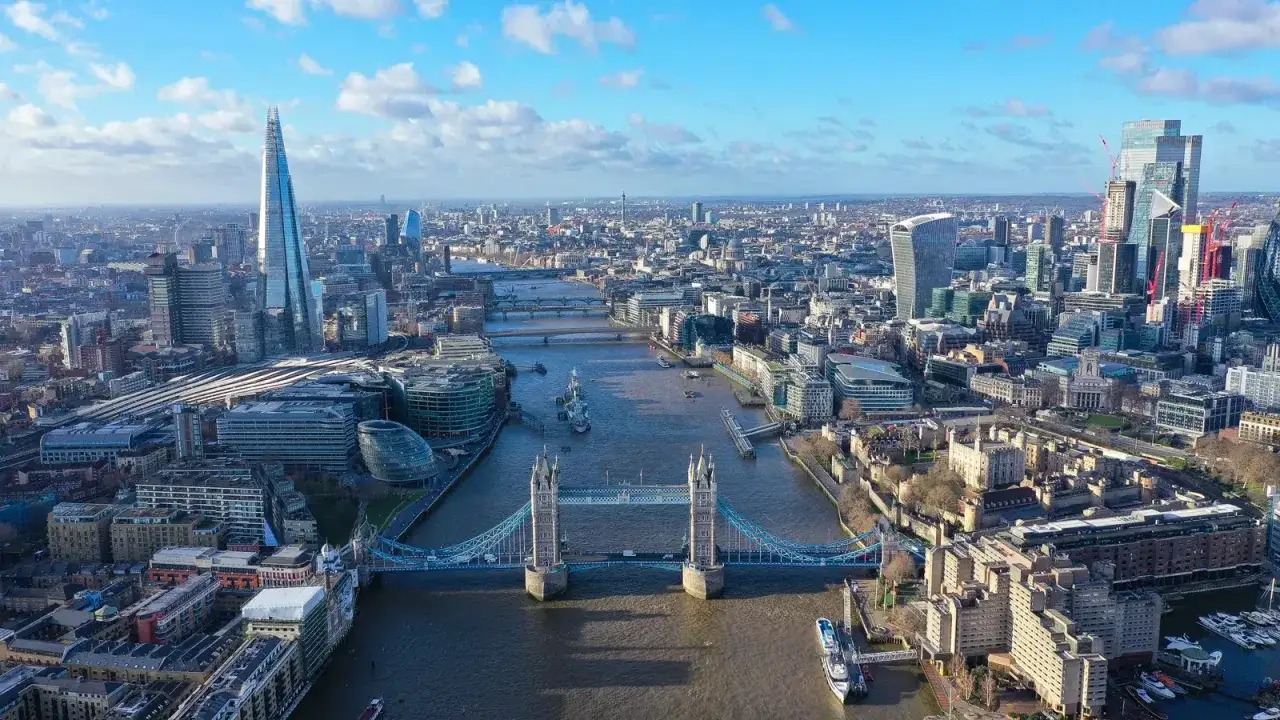 Widok na panoramę Londynu z wieżowcami i charakterystycznym Tower Bridge nad rzeką Tamizą.