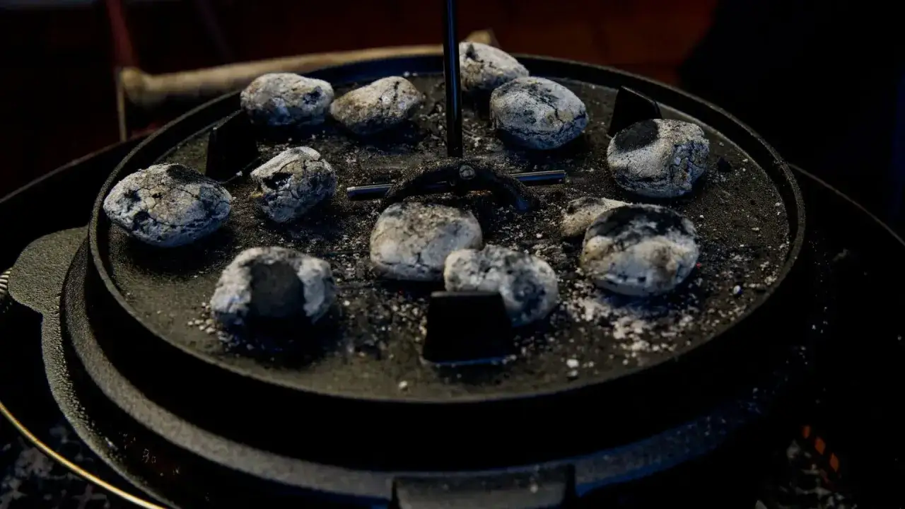 Glühende Kohlen auf einem Dutch Oven, bereit für köstliche Dutch Oven Rezepte.