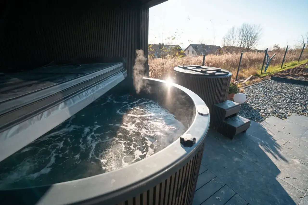 Gorąca kąpiel w jacuzzi, para unosi się nad wodą. Idealne na **sauna przy przeziębieniu**, by poczuć ulgę i rozgrzać ciało.