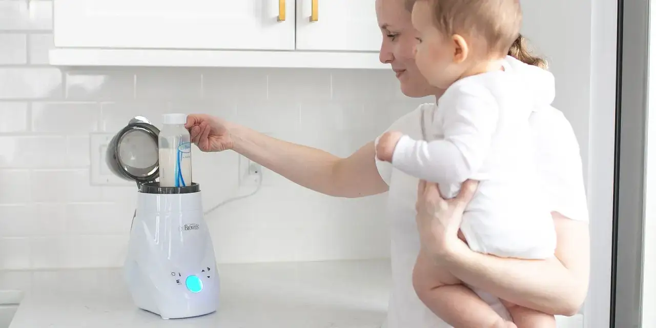 Mama z dzieckiem przygotowuje mleko modyfikowane w podgrzewaczu. Szybko i łatwo.