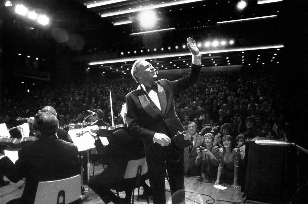 Frank Sinatra winkt seinem Publikum zu. Seine Musikrichtung, der Swing, begeistert die Menge.