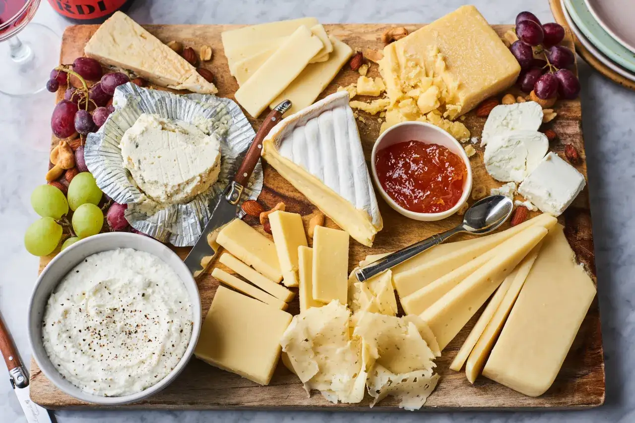 Plateau de fromages vari&eacute;s, un aper&ccedil;u du top 10 des fromages les plus connus au monde, avec raisins, confiture et noix.