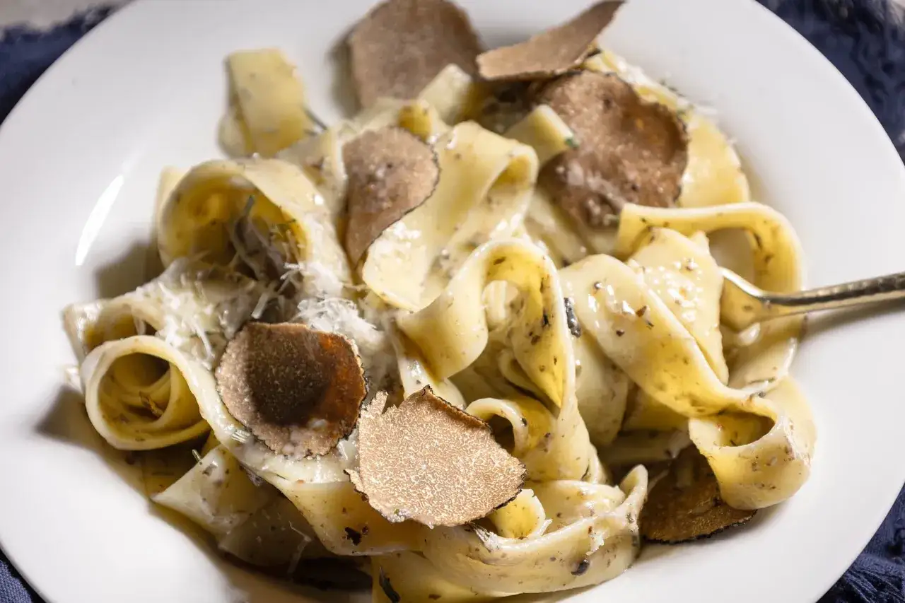 Pappardelle z truflami, posypane parmezanem, tworzą wykwintne danie.
