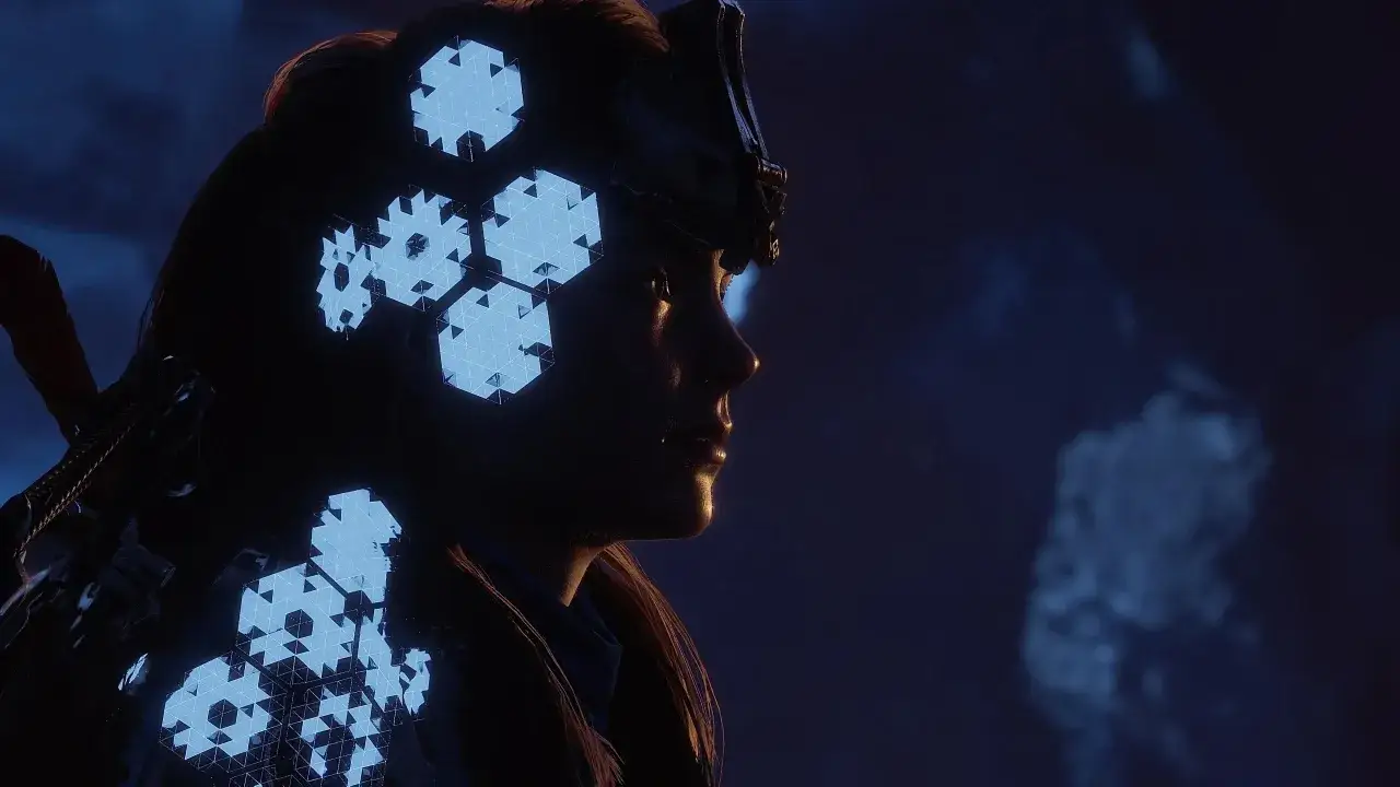 Aloy w ciemności, jej hełm i zbroja ozdobione świecącymi, geometrycznymi wzorami. Odkrywa tajemnice starożytnej zbrojowni w Horizon Zero Dawn.