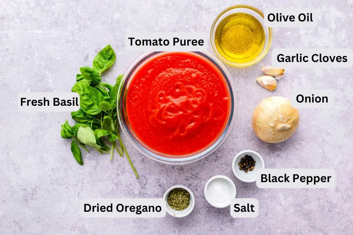 Ingredientes para la mejor salsa de tomate italiana: puré de tomate, albahaca fresca, aceite de oliva, ajo, cebolla, orégano seco, sal y pimienta negra.