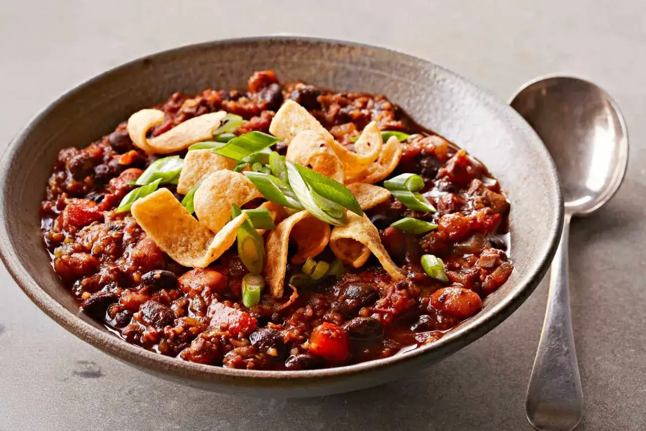 Herzhaftes Chili sin Carne, garniert mit knusprigen Tortilla-Chips und Fr&uuml;hlingszwiebeln, bereit zum Genie&szlig;en.