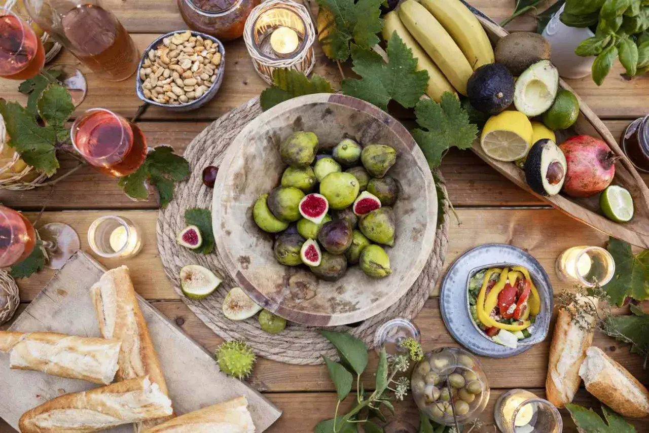 Leckere **Themenabend Essen Ideen**: Feigen, Baguette, Obst, Nüsse und Wein auf Holztisch.