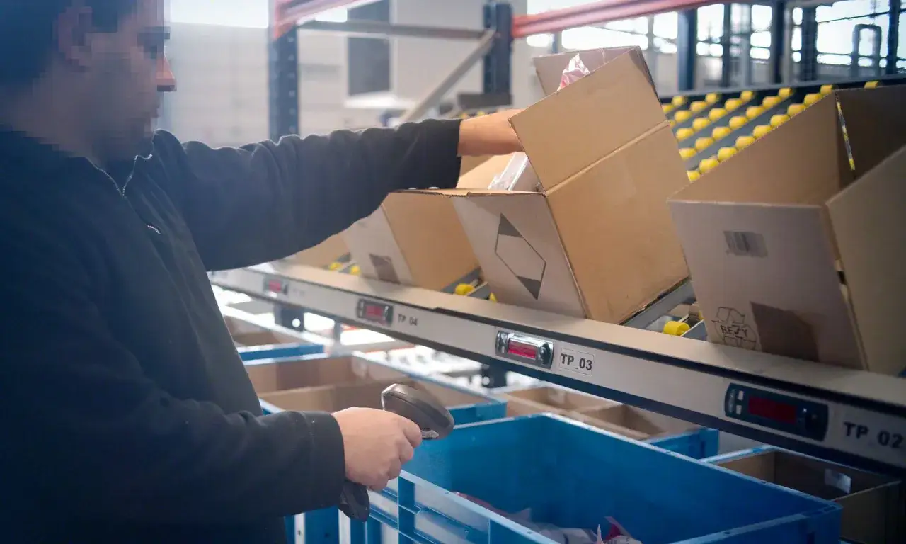 Mitarbeiter scannt Pakete f&uuml;r den multi order picking Prozess.