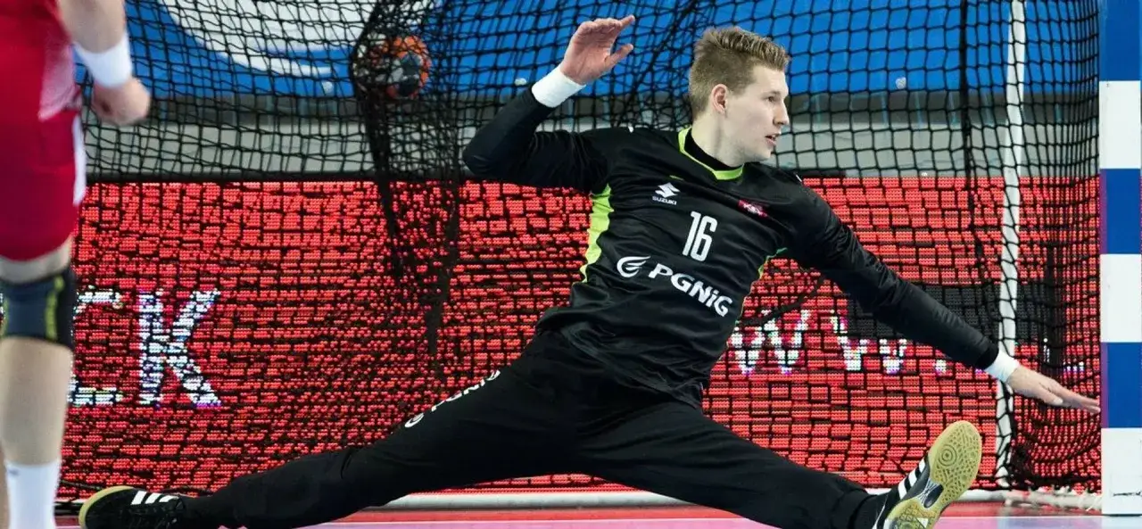 Jakub Biernat w akcji, broniąc bramkę. Bramkarz w czarnym stroju z numerem 16.