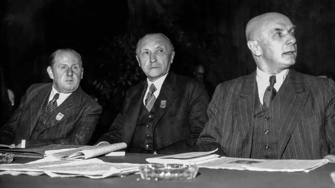 Drei Männer sitzen an einem Tisch. Sie sind Teil der CDU Geschichte.