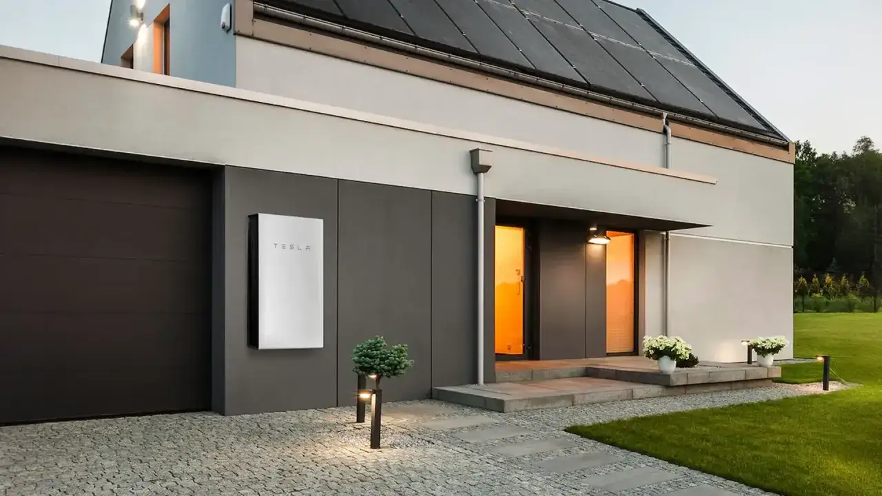 Nowoczesny dom z panelami słonecznymi i magazynem energii Tesla. Dofinansowanie na magazyn energii 2026 może pomóc w takiej inwestycji.