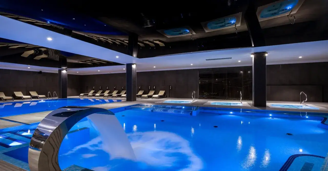 Nowoczesny basen z hydromasażem i leżakami w hotelu Karpacz w Karpaczu.