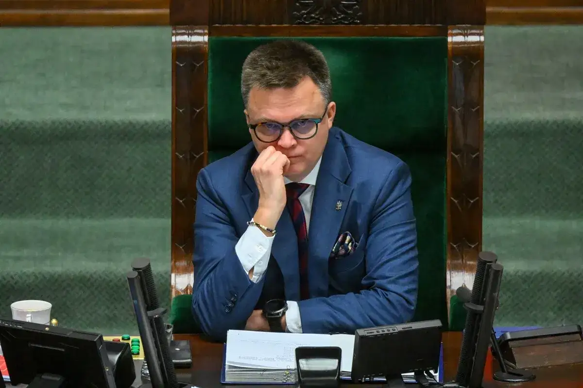 Szymon Hołownia w zamyśleniu, być może zmagający się z chorobą, siedzi w fotelu marszałka.