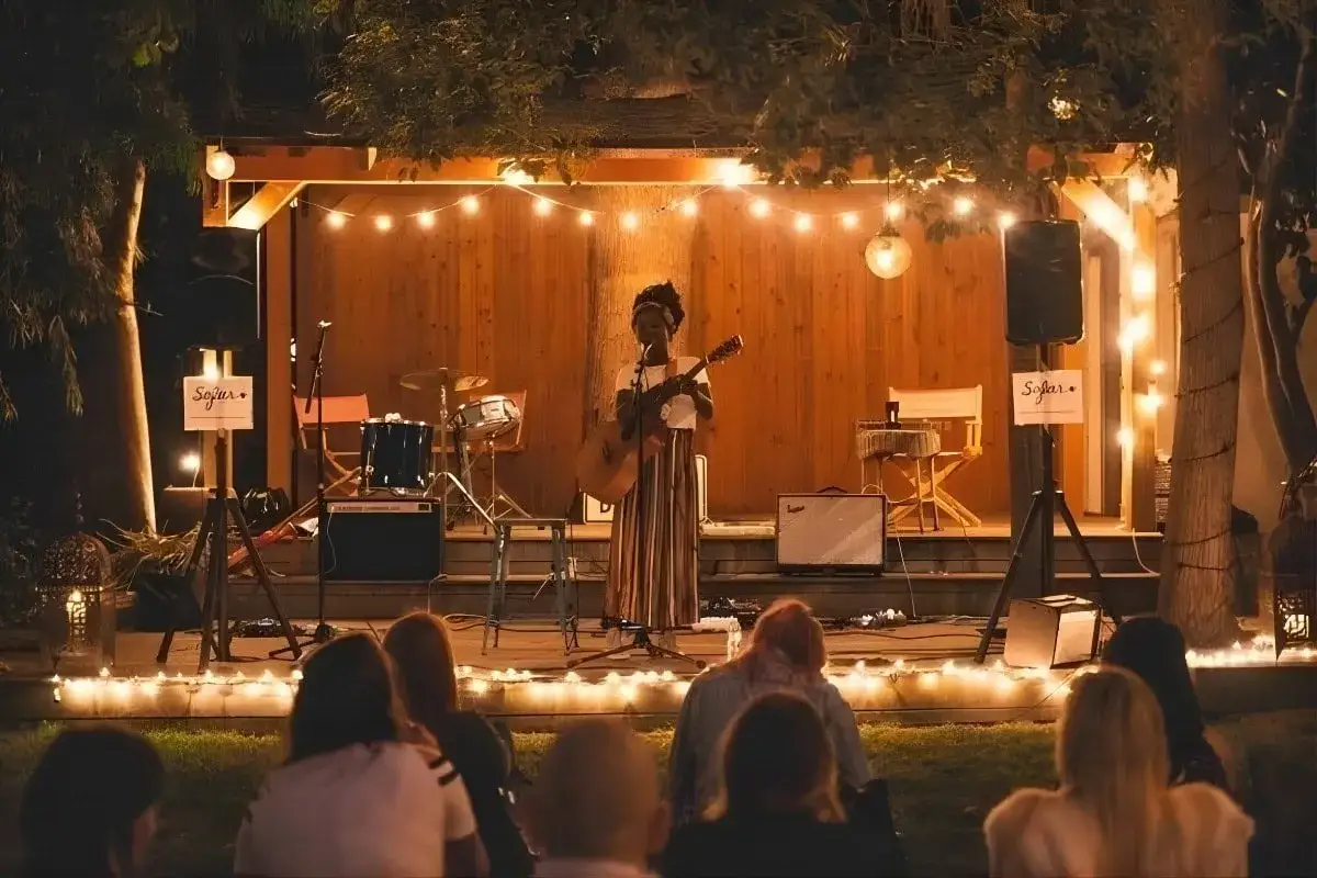 Koncert unplugged co to znaczy? Artystka gra na gitarze przy blasku świateł, tworząc magiczną atmosferę dla publiczności.