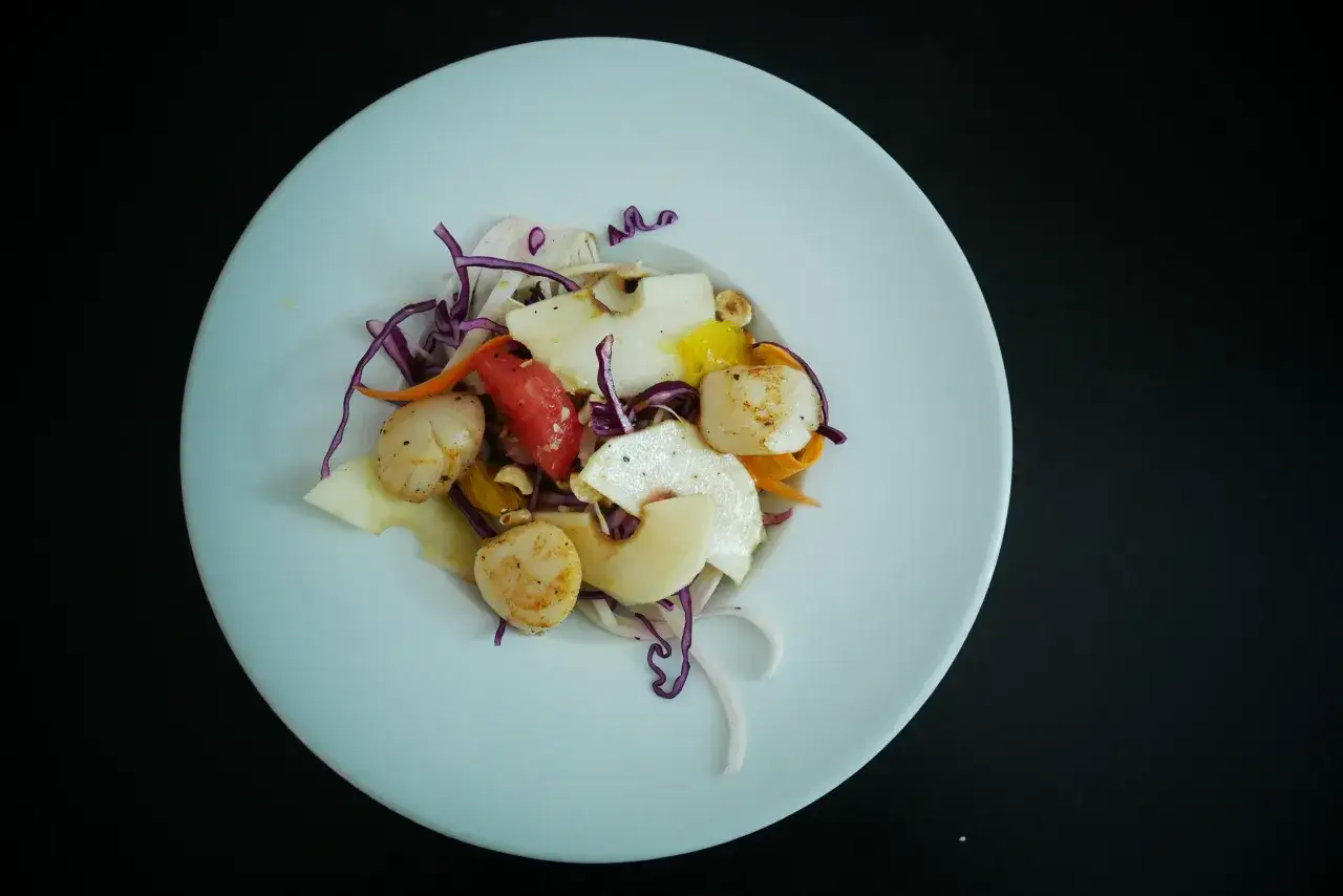 Salade fra&icirc;che avec Saint-Jacques po&ecirc;l&eacute;es, fruits et l&eacute;gumes croquants, un d&eacute;lice parfait avec un vin blanc.