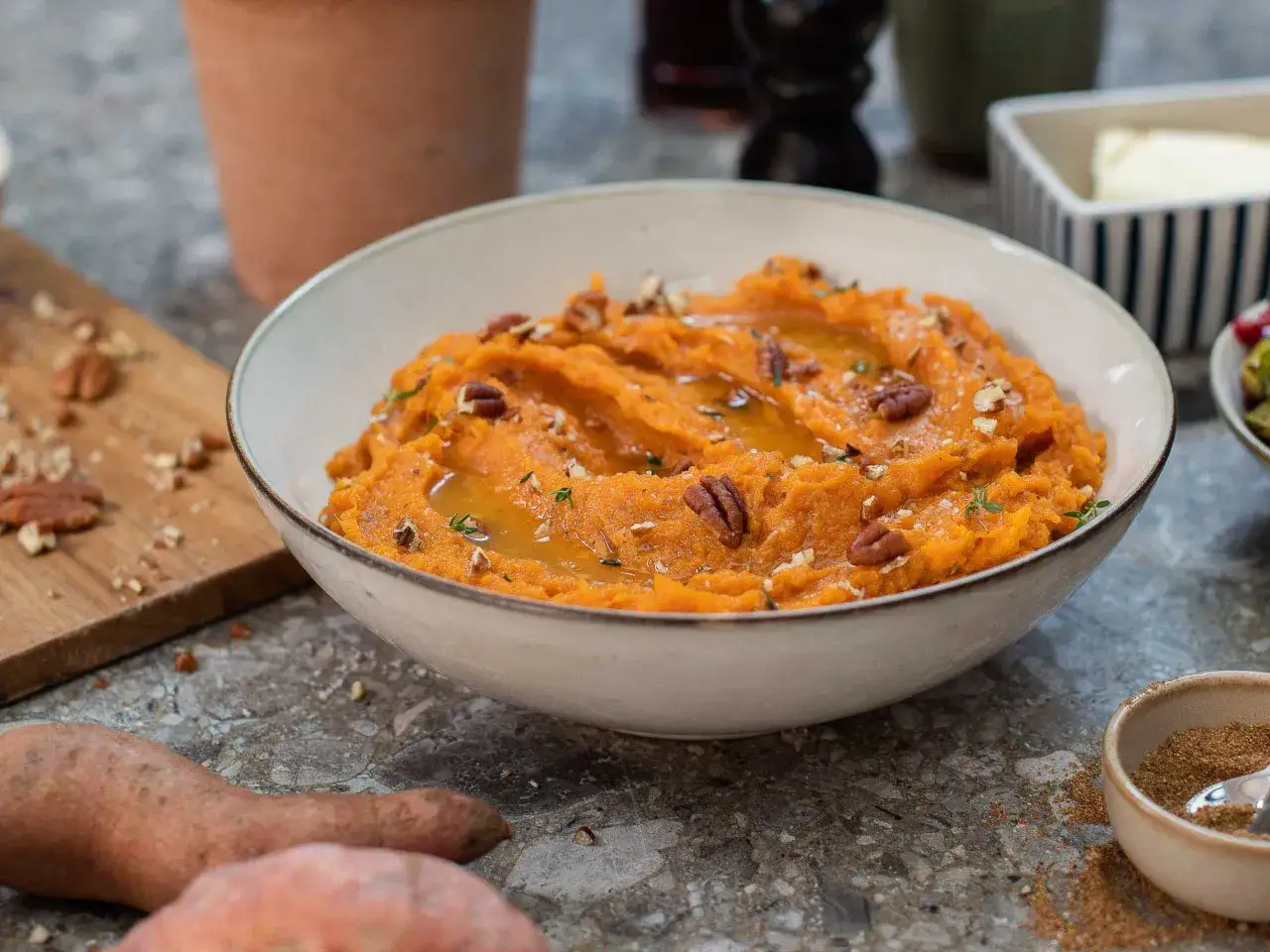Un bol de purée de patate douce onctueuse, garnie de noix de pécan et d'un filet de miel. Un délice automnal !
