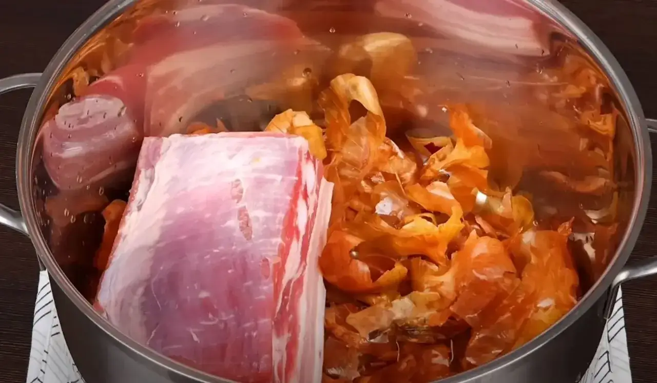 Mięso i wywar z łupin cebuli w garnku.